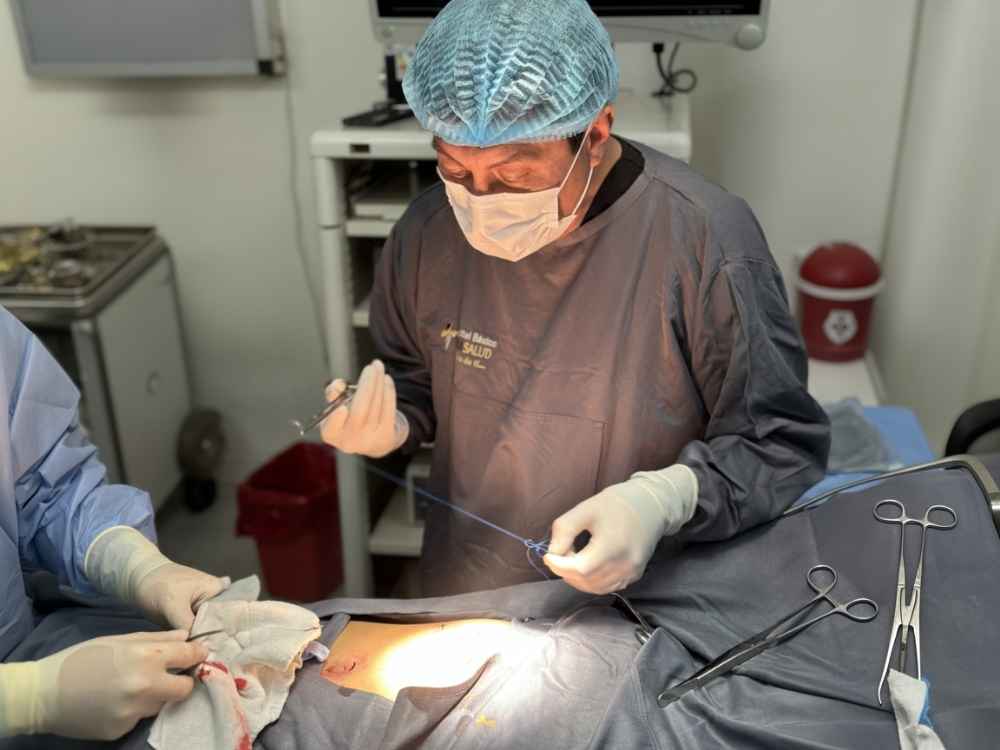 Ginecólogo explicando con modelo anatómico de útero durante una consulta de obstetricia en Clínica NovaSalud, Latacunga.